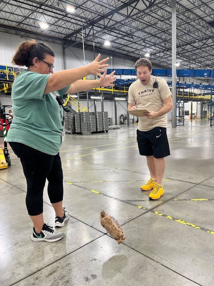 Rebekka Sebree (left) and Justin Edwards, employees at Thrive Market's fulfillment center in Batesville, Indiana, subject a jar of Thrive Market strawberry jam that has been wrapped in honeycombed die-cut paper to a drop test. 