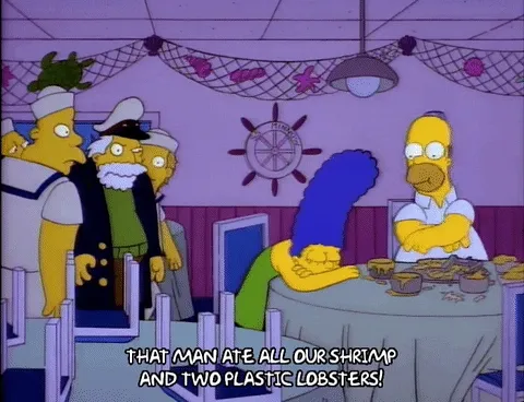 A gif of Homer Simpson stuffing his face at a restaurant with the text of a server in a sailor suit saying, "That man ate all our shrimp and two plastic lobsters!"