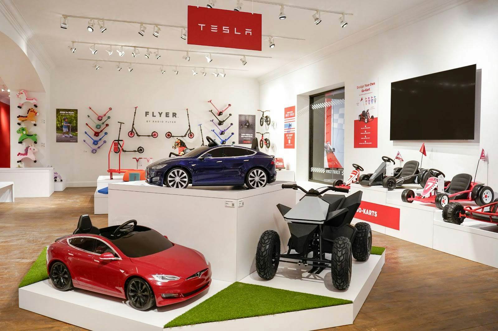 A display inside the Radio Flyer store shows three models of kid-sized Tesla electric vehicles..
