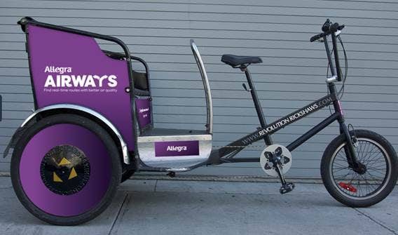 A pedicab that prominently features the logo for Allegra Airways.