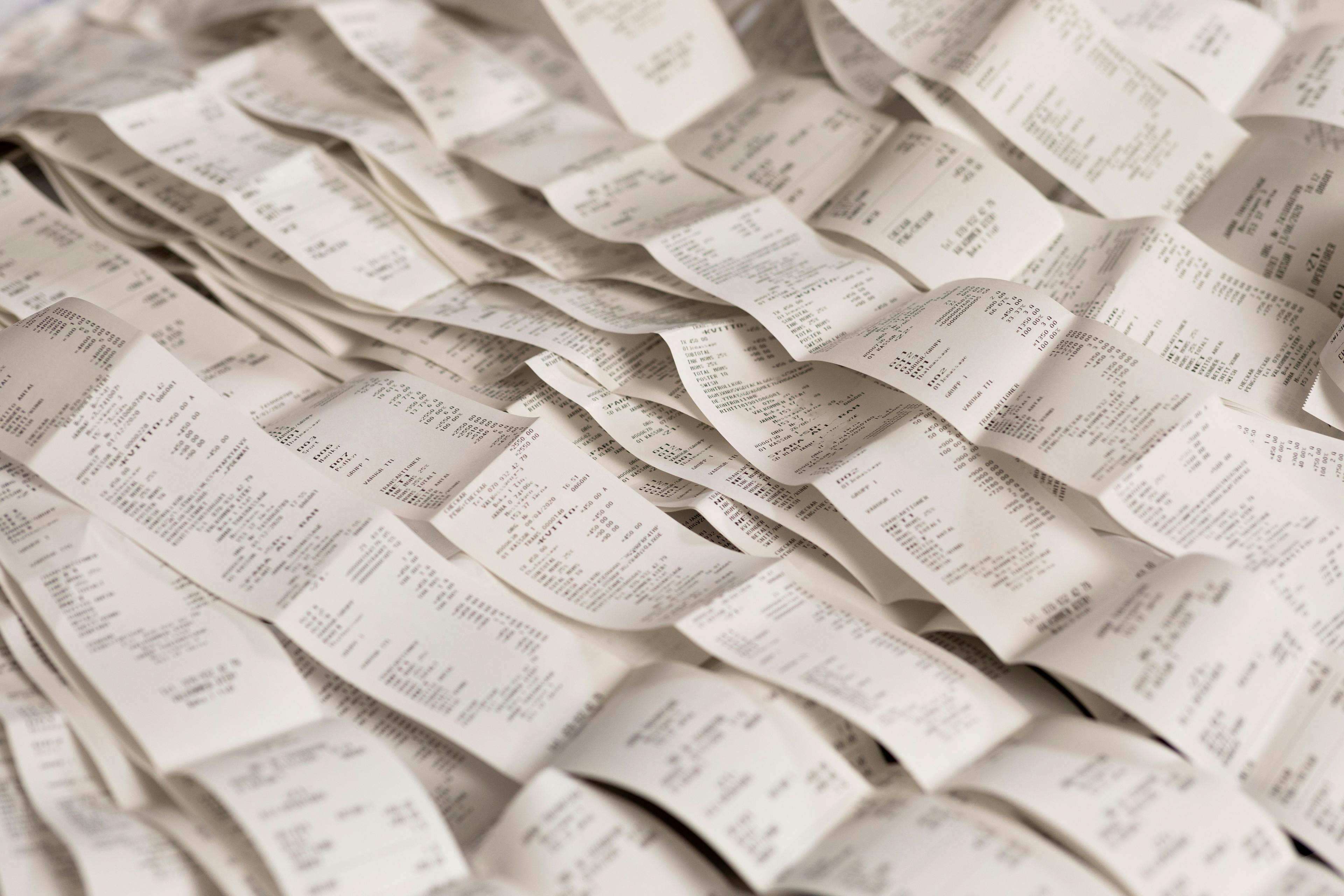 Dozens of receipts displayed on a table. 